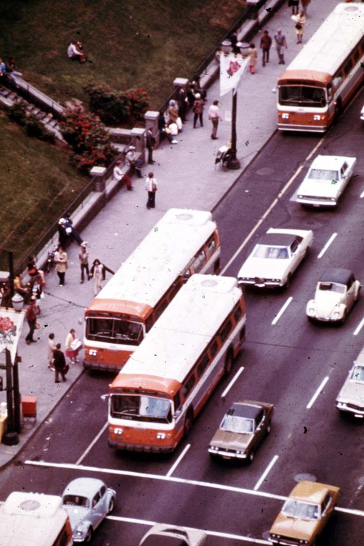 TriMet buses sharing the road with cars in downtown Portland traffic